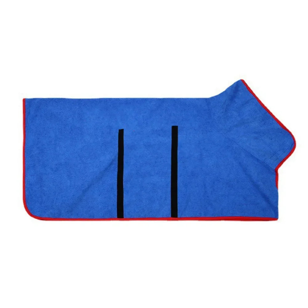 De koningsblauwe badjas met rode bies plat neergelegd, met de buikflap en de twee klittenbandsluitingen zichtbaar.