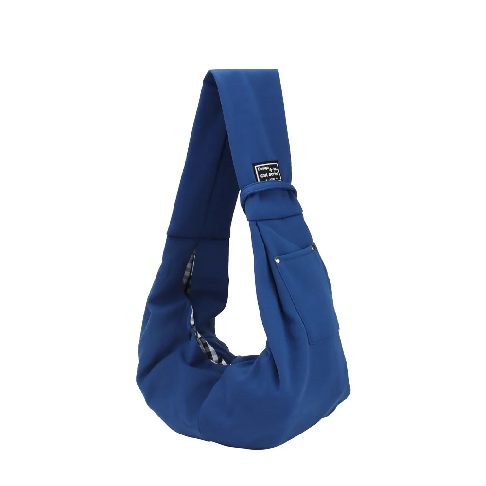 De schoudertas in blauw, met het opgestikte voorvak en de geruite voering langs de opening